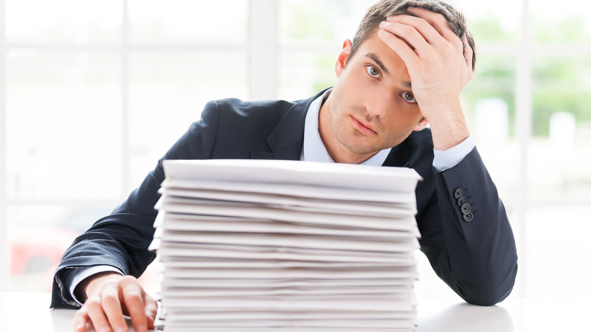 Stressed Businessman With A Stack Of Paperwork